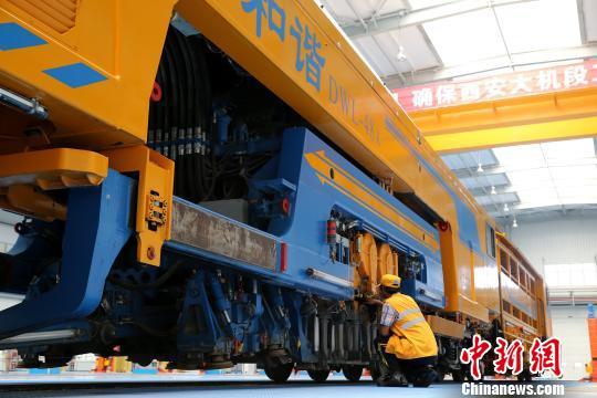 圖為工人正在清理大型養(yǎng)路機(jī)械。　張遠(yuǎn) 攝